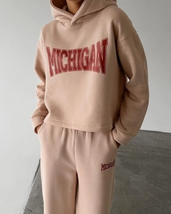 Detail view of beige casual tracksuit with red Michigan varsity print on hoodie and joggers