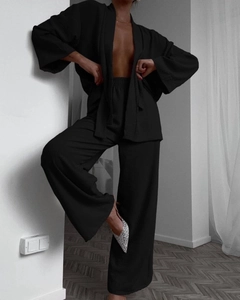 Detail of black lounge set showing textured fabric on kimono top and wide-leg pants