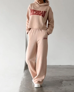 Detail of Michigan lettering on pink cropped hoodie and high-waisted wide-leg sweatpants