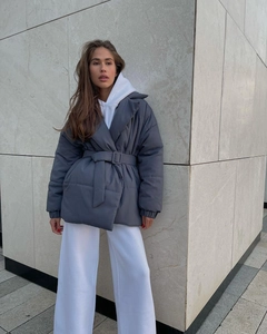 Detail of grey winter coat featuring a large lapel and waist belt for a slim fit look