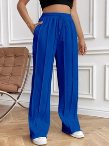 Détail du pantalon large bleu roi avec cordon de serrage, taille élastique et coutures