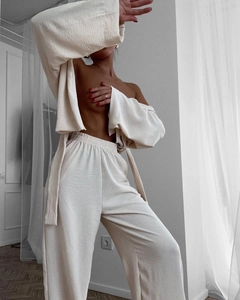 Detailed view of cream-colored pleated lounge set with tied waist and wide-leg pants
