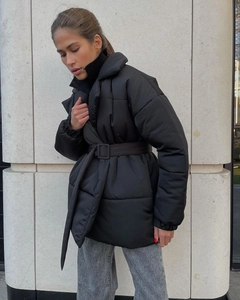 Detail of winter quilted coat featuring a waist-cinching belt and matte black fabric
