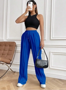 Détail du pantalon large bleu électrique avec plis marqués et cordon de serrage taille