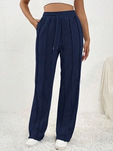 Détail du pantalon large bleu marine avec taille à cordon élastique et coutures verticales