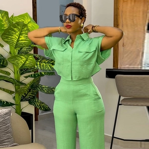 Detail of lime green short sleeve shirt with chest pockets and wide leg pants set