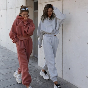 Detail of oversized brick red and heather grey fleece hoodies with kangaroo pockets