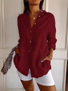 Close-up of wine red button-down shirt featuring textured fabric and front pocket detail