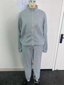 Detail of light gray zip-up fleece tracksuit showing ribbed cuffs and pocket texture