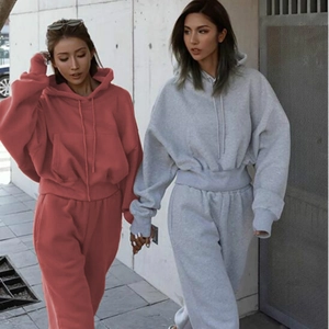 Detail of loose fit hooded sweatshirt and joggers set in brick red and light grey