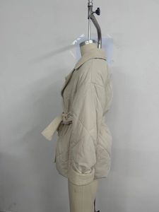 Detailansicht der beigefarbenen Steppjacke mit cremefarbenem Fleecekragen und Bindegürtel