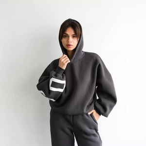 Dettaglio del set felpa con cappuccio grigio scuro con stampa geometrica bianca sulla manica