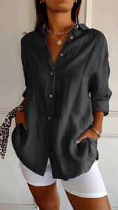 Close-up detail of dark grey pleated fabric and button-down collar on women shirt
