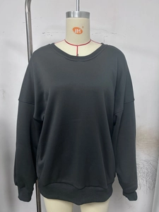 Detail of oversized black long-sleeved sweatshirt with ribbed hem on a mannequin