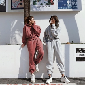 Detail view of brick red and light grey women's hooded sweatshirt and jogger sets