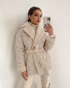 Detail der cremefarbenen Steppjacke mit Lammwollbesatz und passendem Bindegürtel