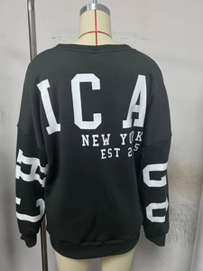 Detail of Chicago and New York lettering on back of black oversized crewneck sweatshirt