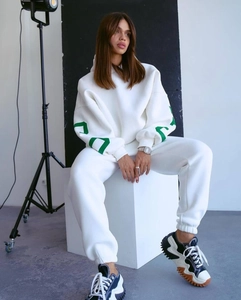 Dettaglio del set felpa bianca oversize con stampe grafiche verdi su entrambe le maniche