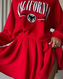 Detail of red California print hoodie and pleated skirt set with vintage emblem