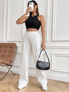Détail du pantalon large blanc à taille haute avec coutures verticales et cordon de serrage