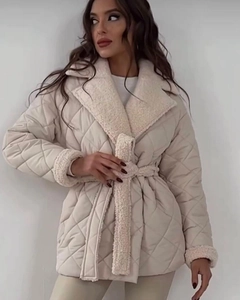 Detail der cremefarbenen Steppjacke mit Lammfellkragen und Taillengürtel zum Binden