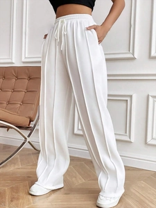 Détail du jogging blanc à jambe large avec cordon de serrage et coutures verticales