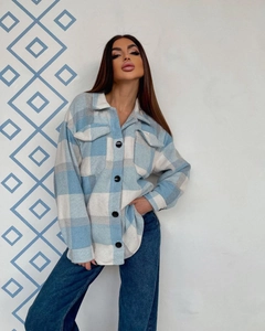 Detailed macro view of the blue plaid texture and front flap pockets on the shacket