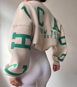Macro view of oatmeal sweatshirt with green Chicago and New York back graphic print
