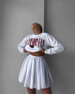 Detail of white California letter print sweatshirt with pleated mini skirt set