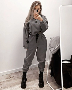 Detail eines dunkelgrauen zweiteiligen Trainingsanzugs mit Fleece und schwarzen Etiketten