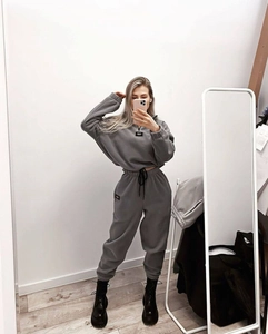 Detail des dunkelgrauen Trainingsanzugs mit Rippbündchen und Aufnäher auf dem Sweatshirt