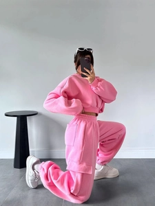 Pink two-piece tracksuit featuring a cropped crewneck sweatshirt and cargo sweatpants