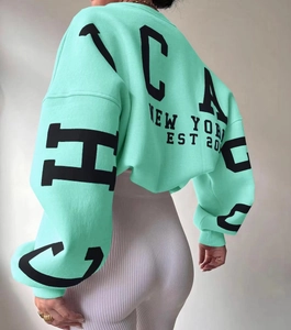 Detail of mint green oversized hoodie featuring black vintage Chicago lettering and ribbed cuffs