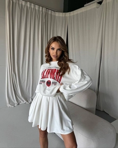 Detail of white sweatshirt with California eagle print and high waist pleated skirt set