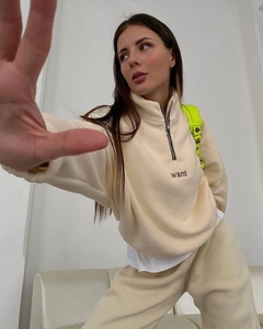 Detail of cream oversized fleece hoodie with quarter zip and want embroidery