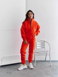 Women's bright orange two-piece lounge set with half-zip sweatshirt and drawstring joggers