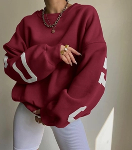 Detail of white geometric print on burgundy oversized sleeve with ribbed cuffs