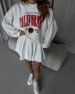 Detail shot of white California oversized sweatshirt and matching pleated mini skirt