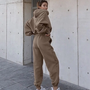 Detail of oversized dark khaki hooded tracksuit in heavyweight cotton fabric outdoors