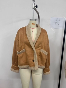 Détail d'une veste en daim marron avec garniture en peau de mouton beige sur le col