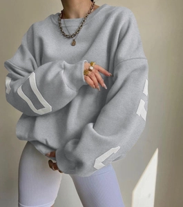 Detailed close-up of grey long sleeve sweatshirt with white sleeve prints and waffle texture