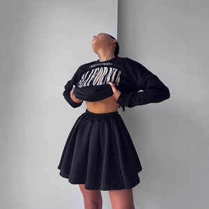 Detail of black pleated mini skirt with elastic waist and street style sweatshirt print