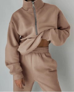 Dettaglio della tuta in pile color kaki con felpa a mezza zip e pantaloni sportivi abbinati