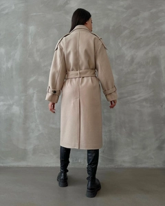 Detail view of oatmeal wool blend coat featuring classic lapels and adjustable waist belt