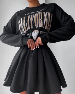 Detail of black oversize sweatshirt with California eagle print and pleated skirt hem