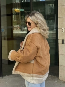 Détail de la veste en daim marron avec doublure en fausse fourrure blanche et finitions