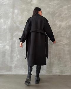Back view of a long black wool coat with waist belt and professional tailored silhouette