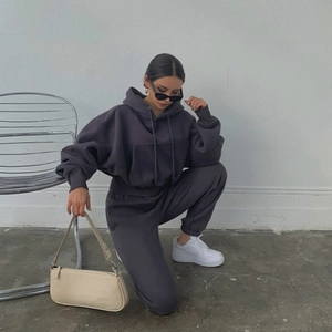 Detailed texture of dark grey hoodie and jogger tracksuit set on a female model