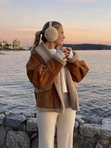 Détail d'une veste en daim caramel et peau lainée avec cache-oreilles blancs au coucher