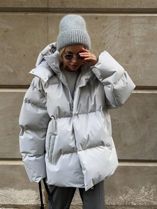 Close-up detail of oversized light grey puffer jacket with matte finish and quilting